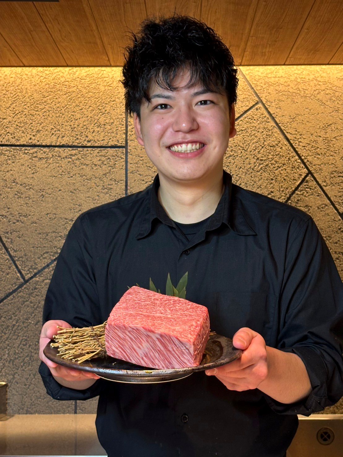A5和牛のかたまりを両手に掲げる店舗スタッフ